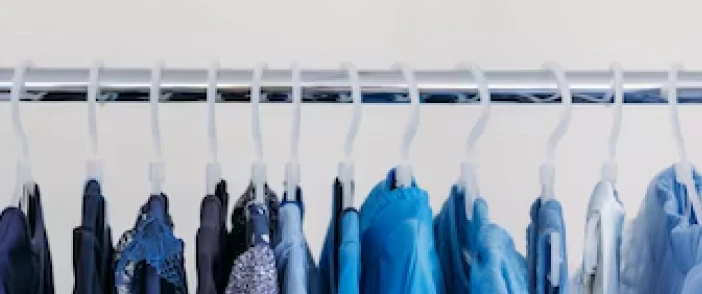 A rack of blue garments on hangers in a retail display