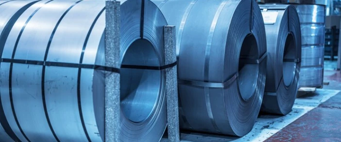 Large rolled steel coils stored on a factory floor