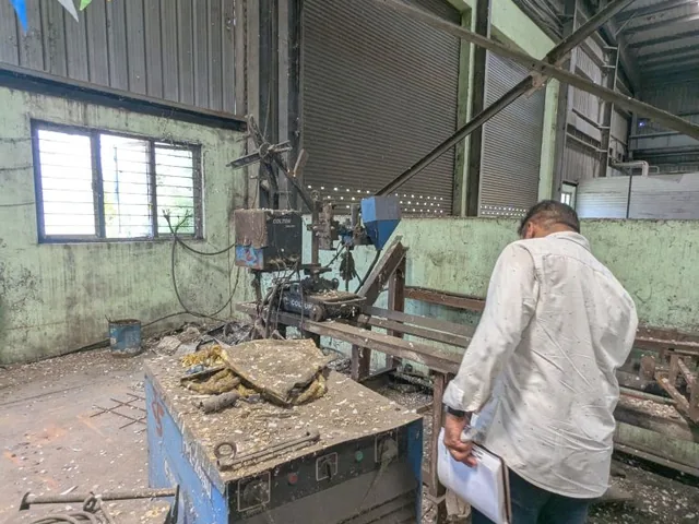 An Axium valuer reviewing inspection notes beside factory equipment