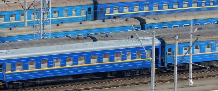 Blue railway passenger coaches in a government rail yard